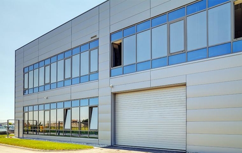 Large two level industrial building with rows of windows.