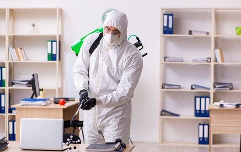 Professional Pest Control Technician treating an office.