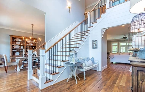 Nice white home interior with hardwood floors and stairs in the middle.